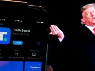 Donald Trump next to a phone with the Truth Social app displayed on it.