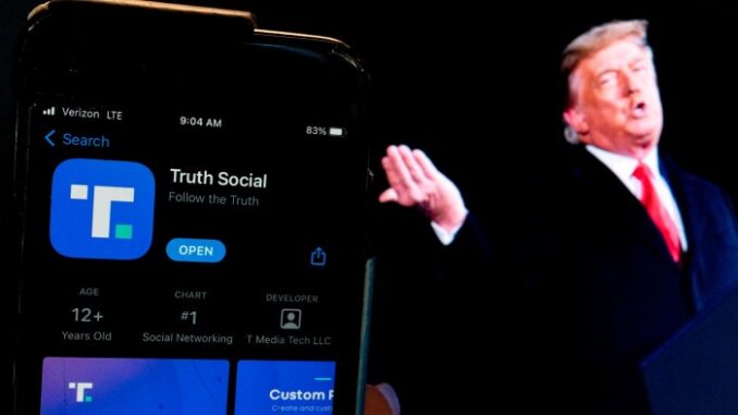 Donald Trump next to a phone with the Truth Social app displayed on it.